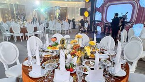 A round dining table with white chairs, surrounded by a white chair arrangement. - EXPO Hotel (Tashkent)