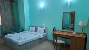 A hotel room with a bed, a desk, a chair, a mirror, and a lamp. - EXPO Hotel (Tashkent)
