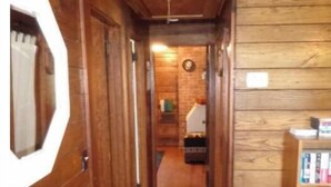 A wooden interior with a leather chair, a small table, and a bookshelf. - Historic year-round cabin along lakeshore w/dock (Andersonville)