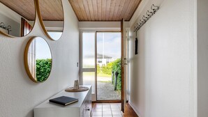 A hallway with a white cabinet, a mirror, and a door leading outside. - Pet friendly home in Slagelse with WiFi (Slagelse)