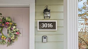 A house number 3016, a porch with a white railing, and a wreath on the door. - Sunset Cottage (Fairfield Bay)
