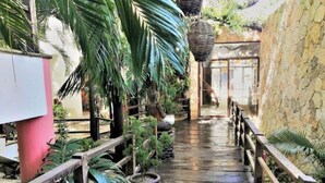 A wooden pathway with railings, surrounded by potted plants and a stone wall. - Twin Room on 5th A06 (Playa del Carmen)