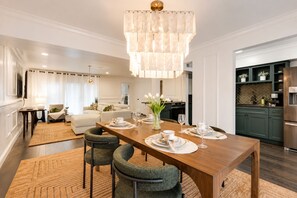 Open dining area with seating for four, featuring a beautiful chandelier..