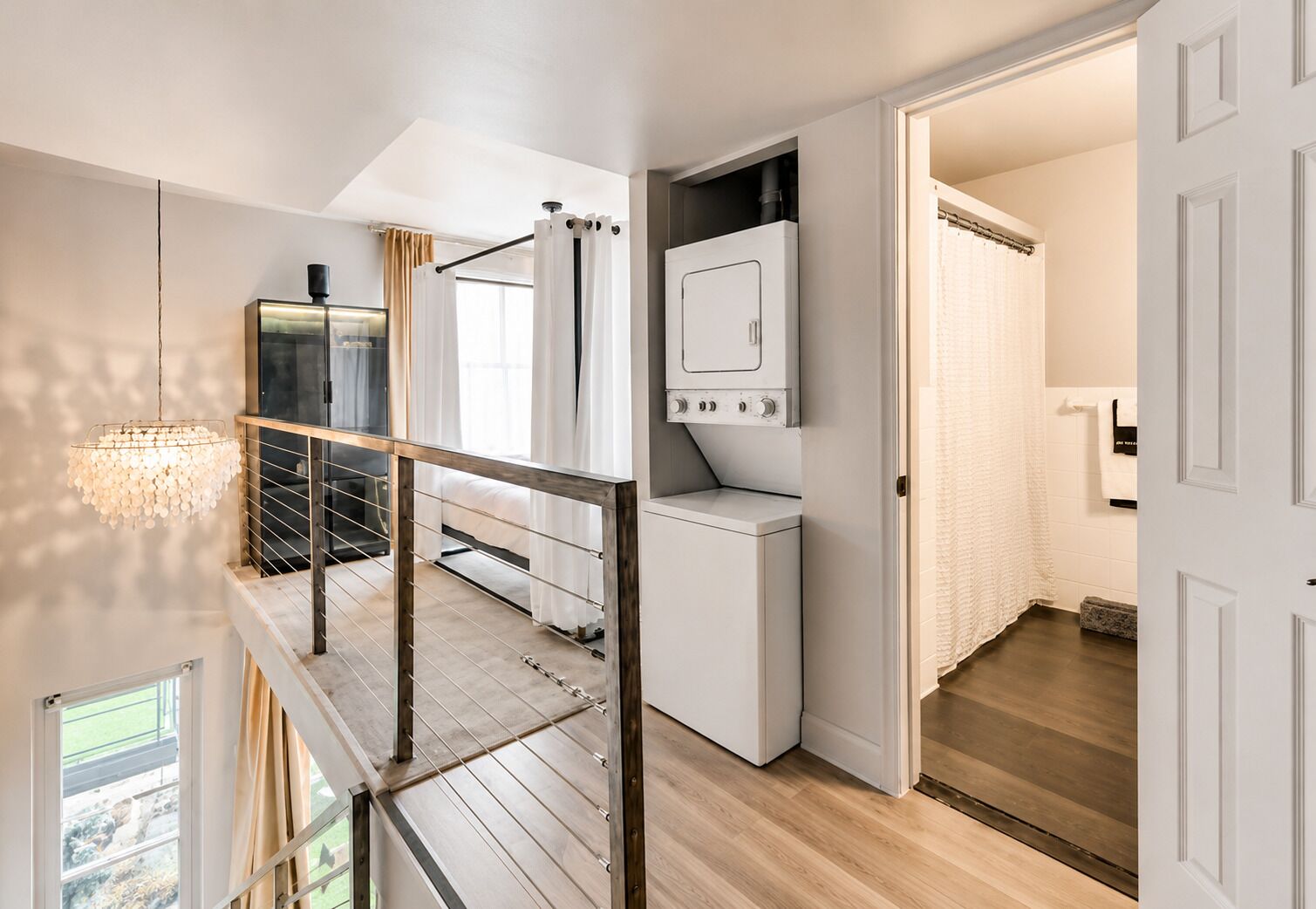 A laundry area with a washing machine, a drying rack, and a ceiling-mounted light fixture.