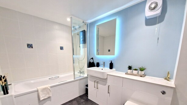 A modern bathroom with a bathtub, a toilet, a sink, and a mirror. - 2 x 3 Bedroom houses side by side quiet peaceful location , Amazing views. (Marazion)
