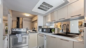 A modern kitchen with stainless steel appliances, a built-in microwave, and a sink.