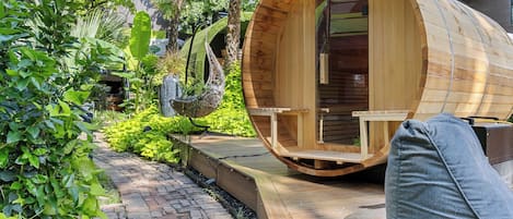Una estructura cilíndrica de madera con una puerta y un banco en el exterior.