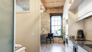 Una cocina moderna con un amplio ventanal, un comedor con una silla y una pequeña mesa.
