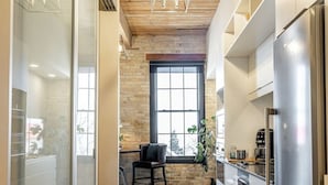Una cocina moderna con techo de madera, electrodomésticos de acero inoxidable y un ventanal grande.