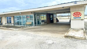 A building with a 'AAA Approved' sign, a bench outside, and a paved entrance area.