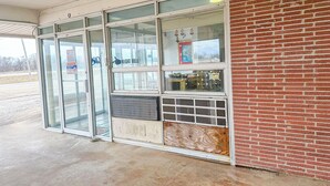 A building with large glass doors and windows, a brick wall, and a sign that reads "NIGHT BELL".