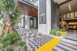Welcome to our hotel, featuring a clean and contemporary design with a geometric pathway leading to the main entrance.
