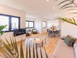 Una sala de estar moderna con un sof á, una mesa de centro y un televisor montado en la pared.