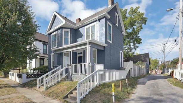 A two-story house with a front porch, a staircase, and a driveway. - Charming 2-bedroom house with AC, WiFi in Columbus (Columbus)