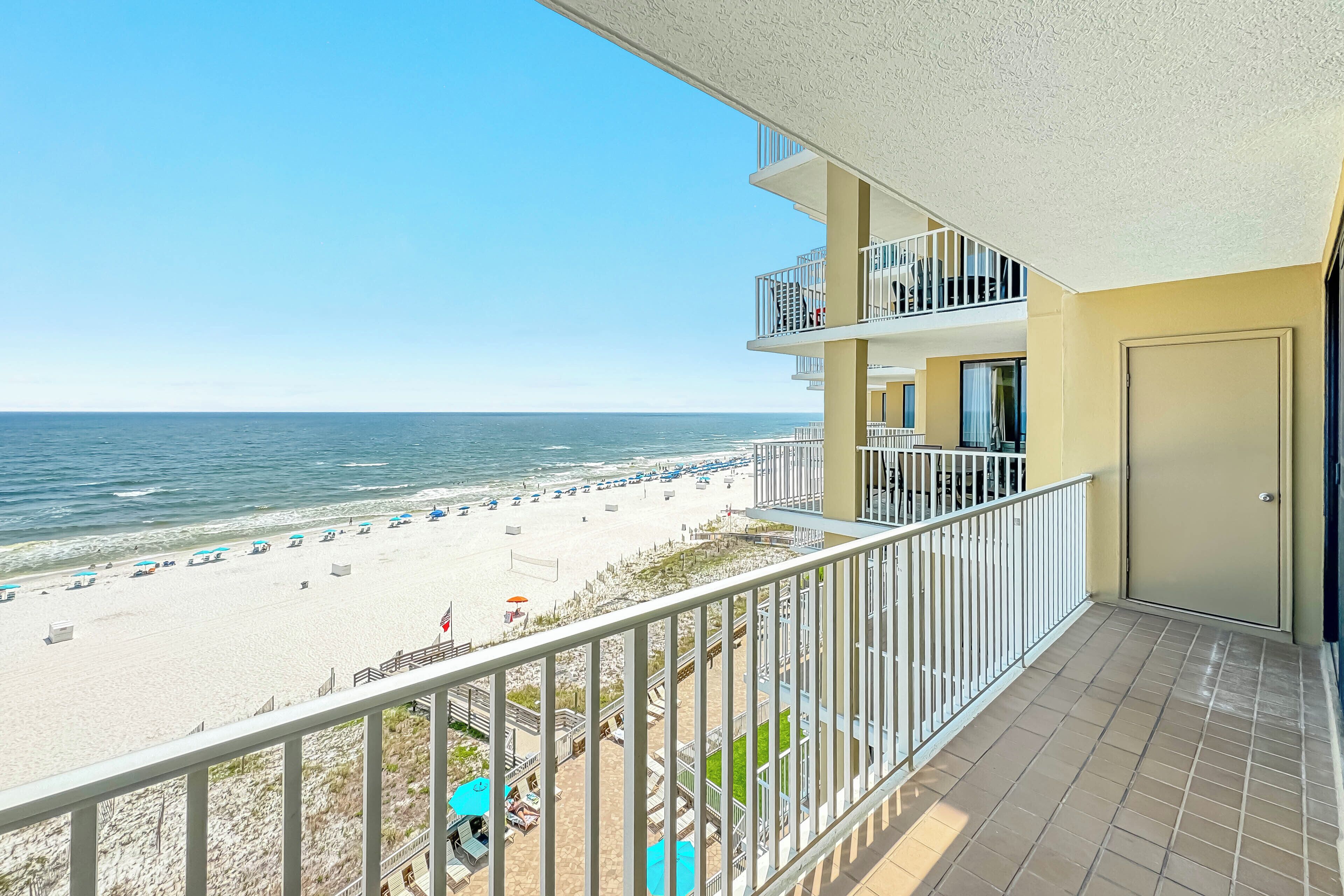 A balcony with a view of a beach and ocean.