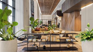 A modern lobby with a sofa, coffee table, and potted plants. - 2409 - Spacious 1BR w Balcony & Stunning Views - Pool, Gym, Near Arena & Bayside (Miami)