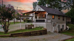 A two-story house with a porch, a wooden fence, and a gravel driveway. - Charming 3br Property with fenced in downtown Mooresville, NC (Mooresville)