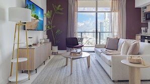 Uma sala de estar moderna com um sofá, uma mesa de centro e uma televisão na parede.