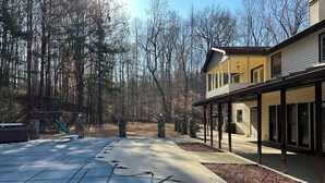 A residential area with a covered patio, a fenced yard, and a house with a balcony. - Luxury Estate Accommodations, with a Serene Pool, and Elegant Event Spaces (Douglasville)