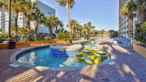 A pool area with a hot tub, palm trees, and lounge chairs. - Romantic Oceanfront 1-Br w/ Balcony (Myrtle Beach)