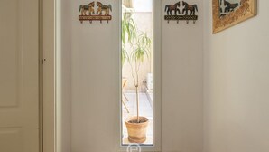 Eine Tür mit einem Blumentopf, einem Spiegel und zwei Wandbildern von Pferden.