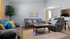 A modern living room with a grey sofa set, a coffee table, and a patterned rug. - New! Spacious 4 Bed Great for Commuting, Dogs ok (Columbia)