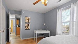A bedroom with a bed, a desk, and a window with curtains. - New! Spacious 4 Bed Great for Commuting, Dogs ok (Columbia)