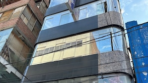 A building with a glass facade displaying mannequins in various outfits. - Hotel Paraíso L&M (Huánuco)