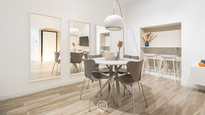 A modern dining area with a round table, chairs, and pendant lighting. - Sofia House - City Centre (Cagliari)