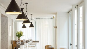 Ett modernt bardis med en bänkskiva i marmor, barstolar och hängande lampor.