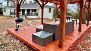 A covered outdoor seating area with a grill, wicker furniture, and a wooden deck. - Stylish 2BRM APT: Putting Green: 1mi Masters: 2mi Medical Center (Augusta)