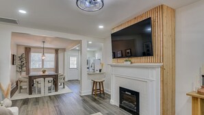 A modern living room with a fireplace, a dining area, and a kitchen. - Organic Modern Apt: 1mi to Masters with Pool Table (Augusta)