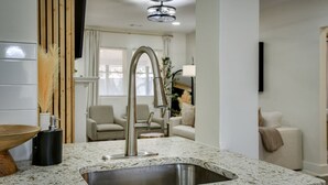 A modern kitchen with a stainless steel sink, a wooden bowl, and a black container. - Organic Modern Apt: 1mi to Masters with Pool Table (Augusta)