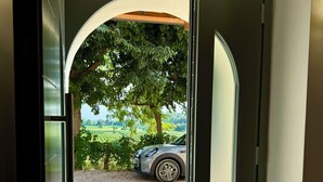 Una entrada moderna amb una porta de vidre que condueix a un camí de grava i un cotxe estacionat.