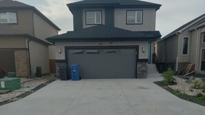 Une allée menant à une maison, avec un garage et le numéro 131.