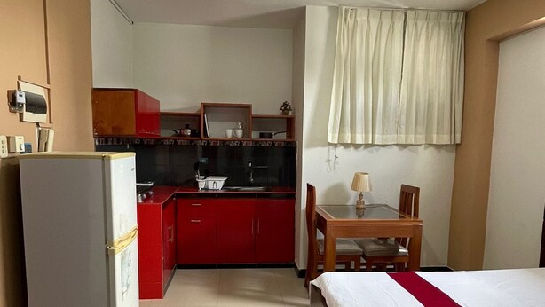 A compact hotel room with a kitchenette, a bed, a desk, and a chair. - Apart hotel Emanuel & Cavita  (Iquitos)