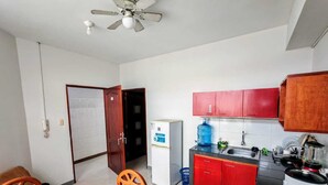 A compact kitchen with a refrigerator, sink, and red cabinets. - Apart hotel Emanuel & Cavita  (Iquitos)
