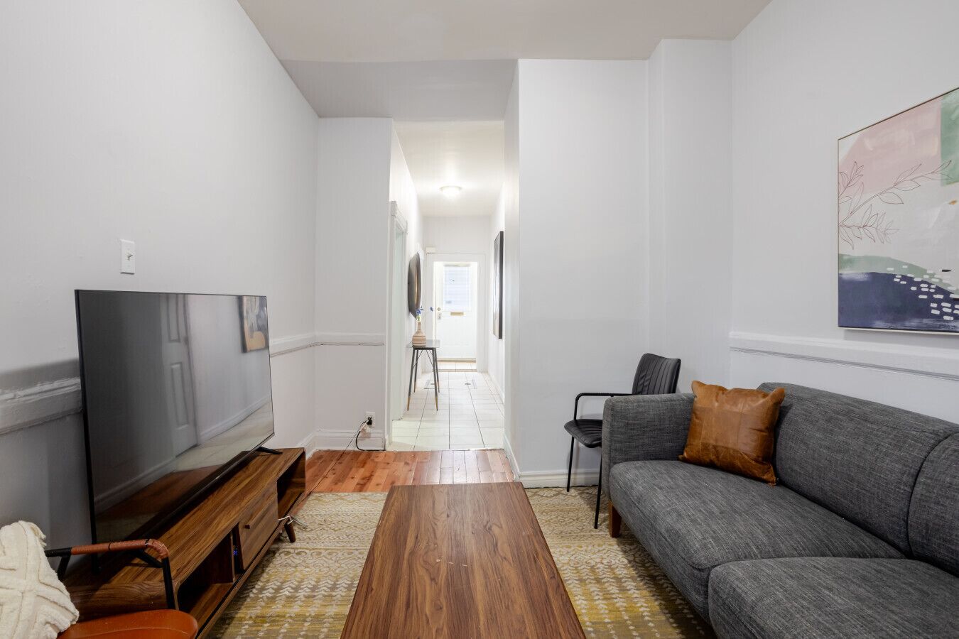 A living room with a television, sofa, and wooden coffee table.