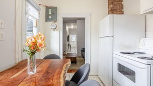 Eine Küche mit Holztisch, Kühlschrank und einem Essbereich mit Stühlen.