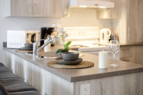 A modern kitchen with a built-in microwave, a coffee maker, and a sink.