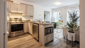 Een moderne keuken met roestvrijstalen apparatuur, houten keukenkastjes en een centraal eiland.