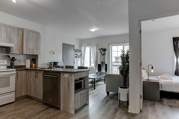 A modern kitchen with wooden cabinets, a built-in oven, and a dining area with a table and chairs.