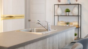 A kitchen island with a stainless steel sink and a modern faucet. - Luxurious 4 BR Suite in Griffintown (Montréal)