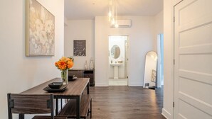 Un coin repas avec une table et des bancs en bois, un vase de fleurs et un tableau accroché au mur.