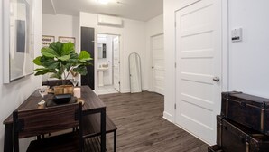 Un interior moderno con una mesa de comedor, sillas, una planta en maceta y una puerta blanca.