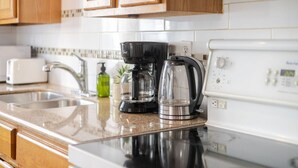 Eine Küche mit einem Edelstahlherd, einer Kaffeemaschine und einem Toaster.