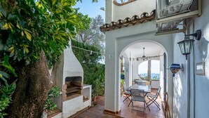 Une terrasse dotée d’un four en briques, d’un espace salon extérieur et offrant une vue sur le paysage.