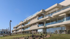 A multi-story hotel with a modern architectural design, featuring balconies and large windows.