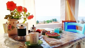 Une table avec une tasse de café, un vase de fleurs et une assiette de nourriture.