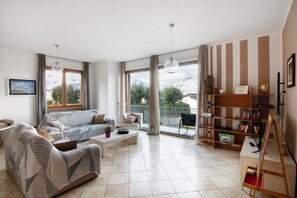 A spacious living area with a sofa, coffee table, and a bookshelf.